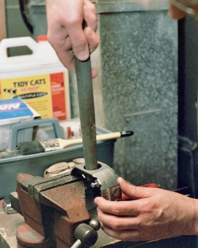 Smoothing up the exhaust port with large half-round file (c) 2004 Larry Cottrill