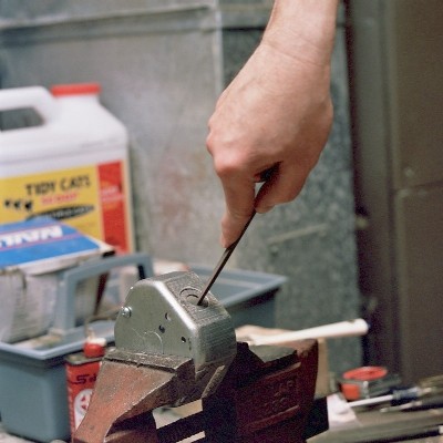 Finishing the spark plug hole with the round file (c) 2004 Larry Cottrill