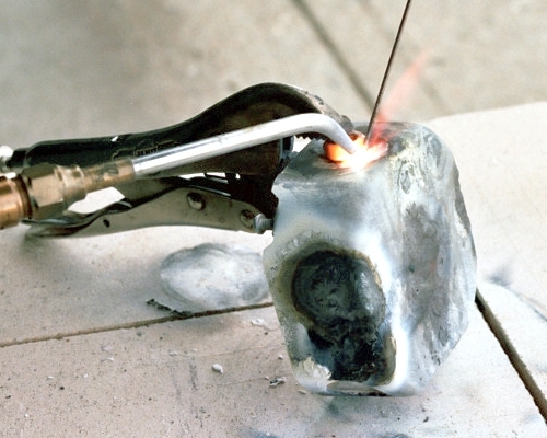 Tack welding the spark plug nut over the hole (c) 2004 Larry Cottrill