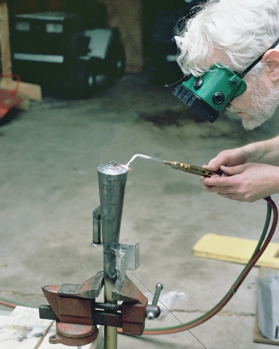 Welding the front end dome onto the combustion chamber cone (c) 2004 Larry Cottrill