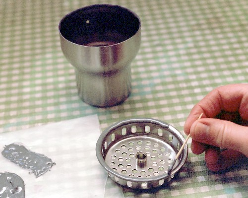 Applying J-B Weld to the rim of the flameholder before setting the diffuser in place (c) 2003 Larry Cottrill