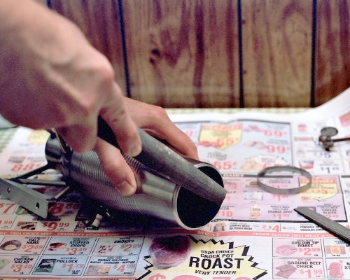 Smoothing up the exhaust port with a large, coarse half-round file (c) 2003 Larry Cottrill