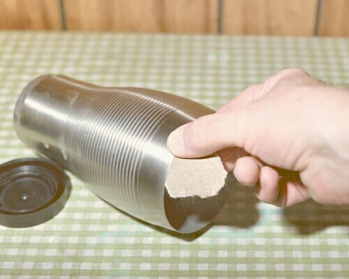 Using sandpaper to roughen the inner rim of the combustor shell before gluing (c) 2003 Larry Cottrill